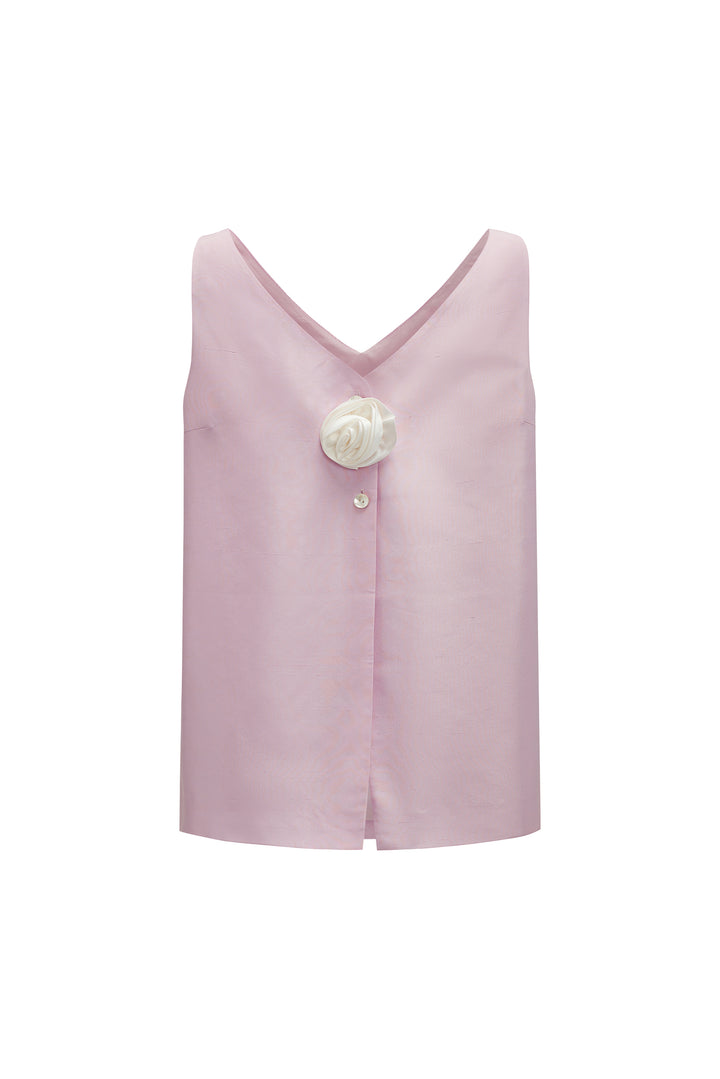 Pink sleeveless top with a white flower and button details on a white background