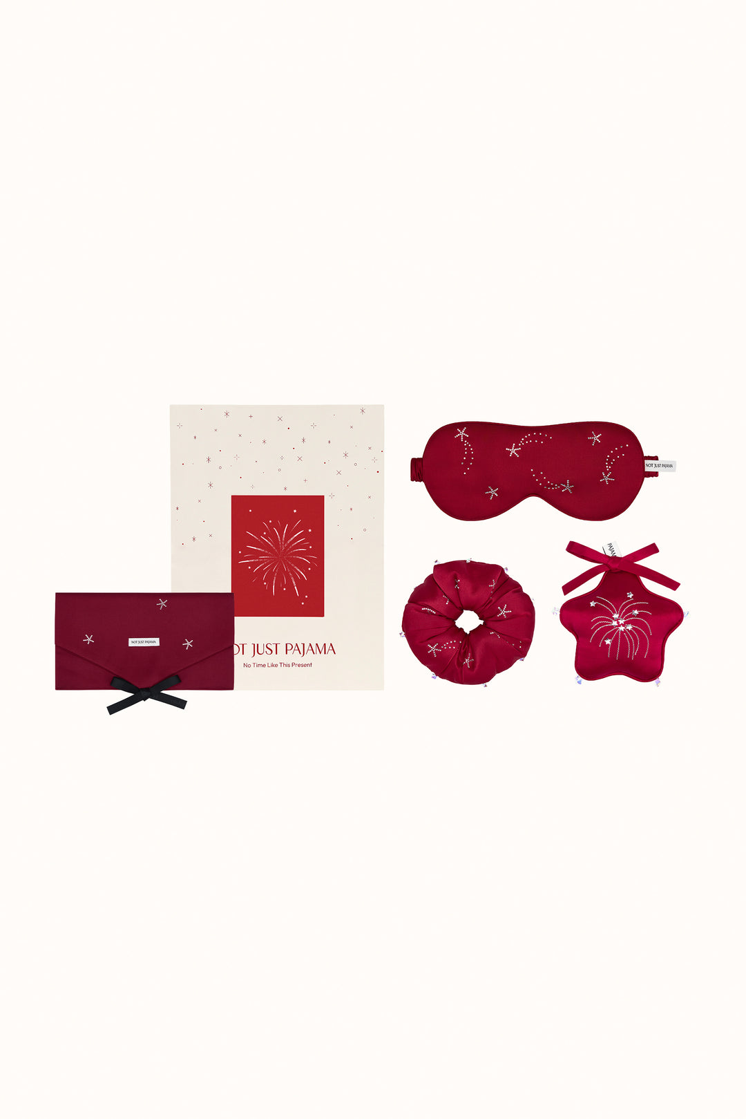 Set of red sleep accessories including a mask, eye pillow, and two small bags on a white background.