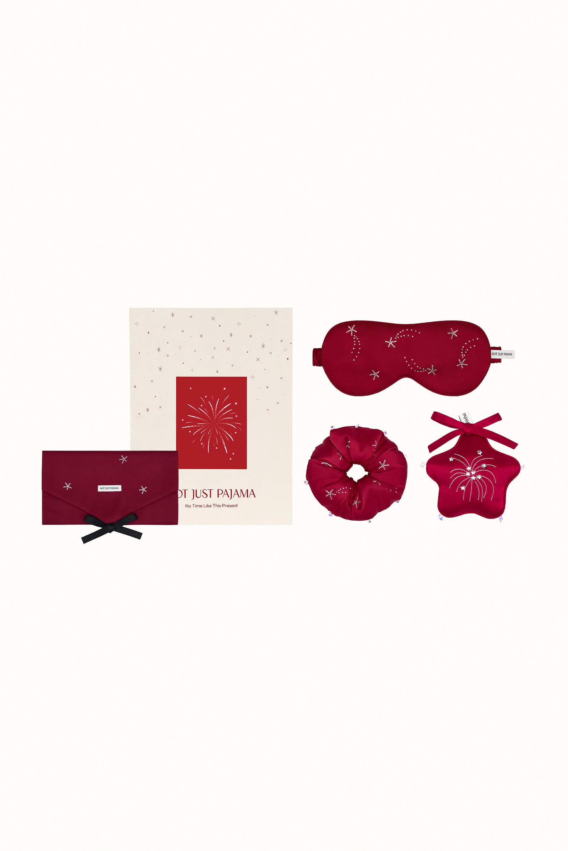 Set of red sleep accessories including a mask, eye pillow, and two small bags on a white background.