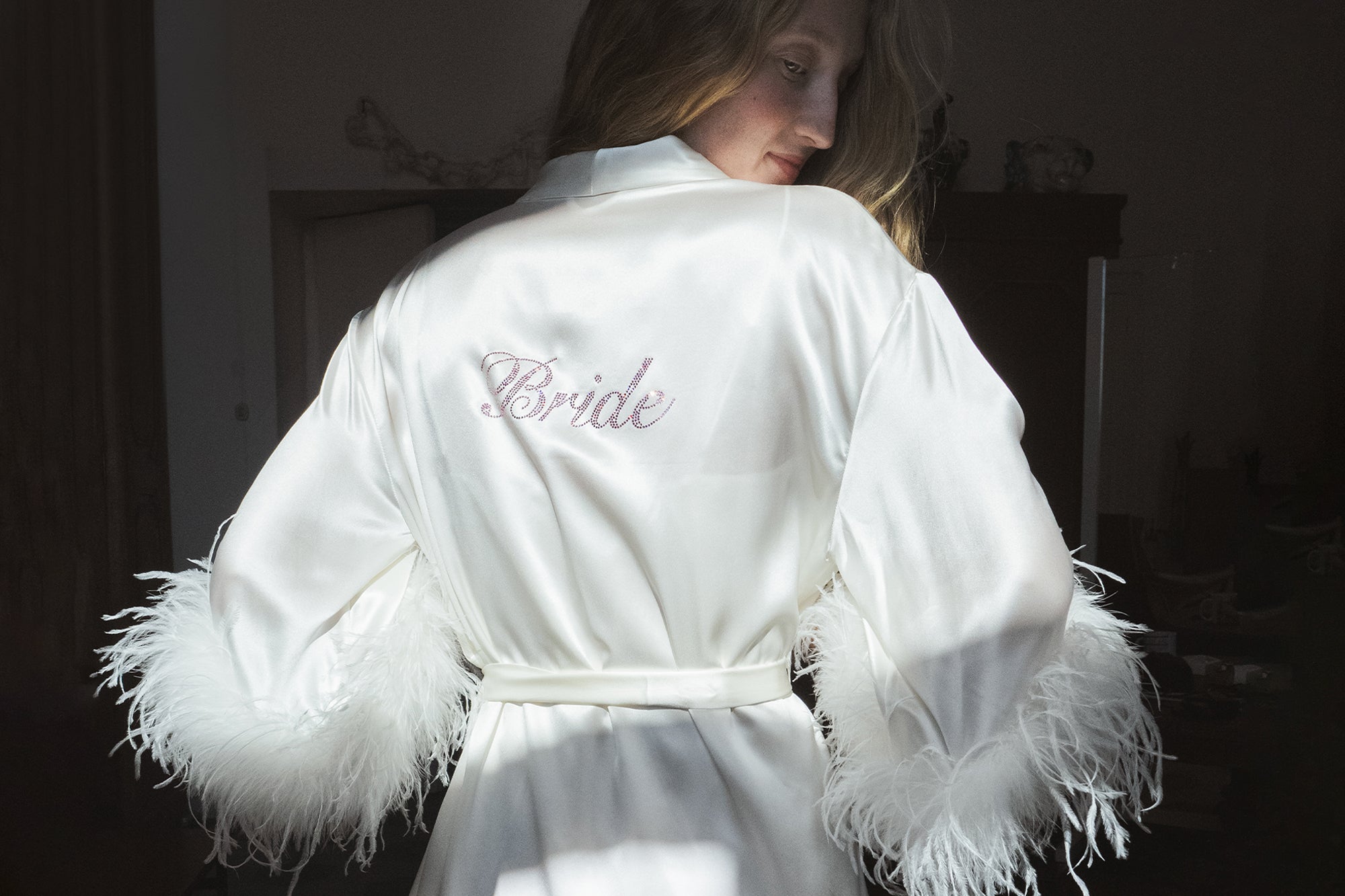 White robe with 'Bride' embroidery on a dark background