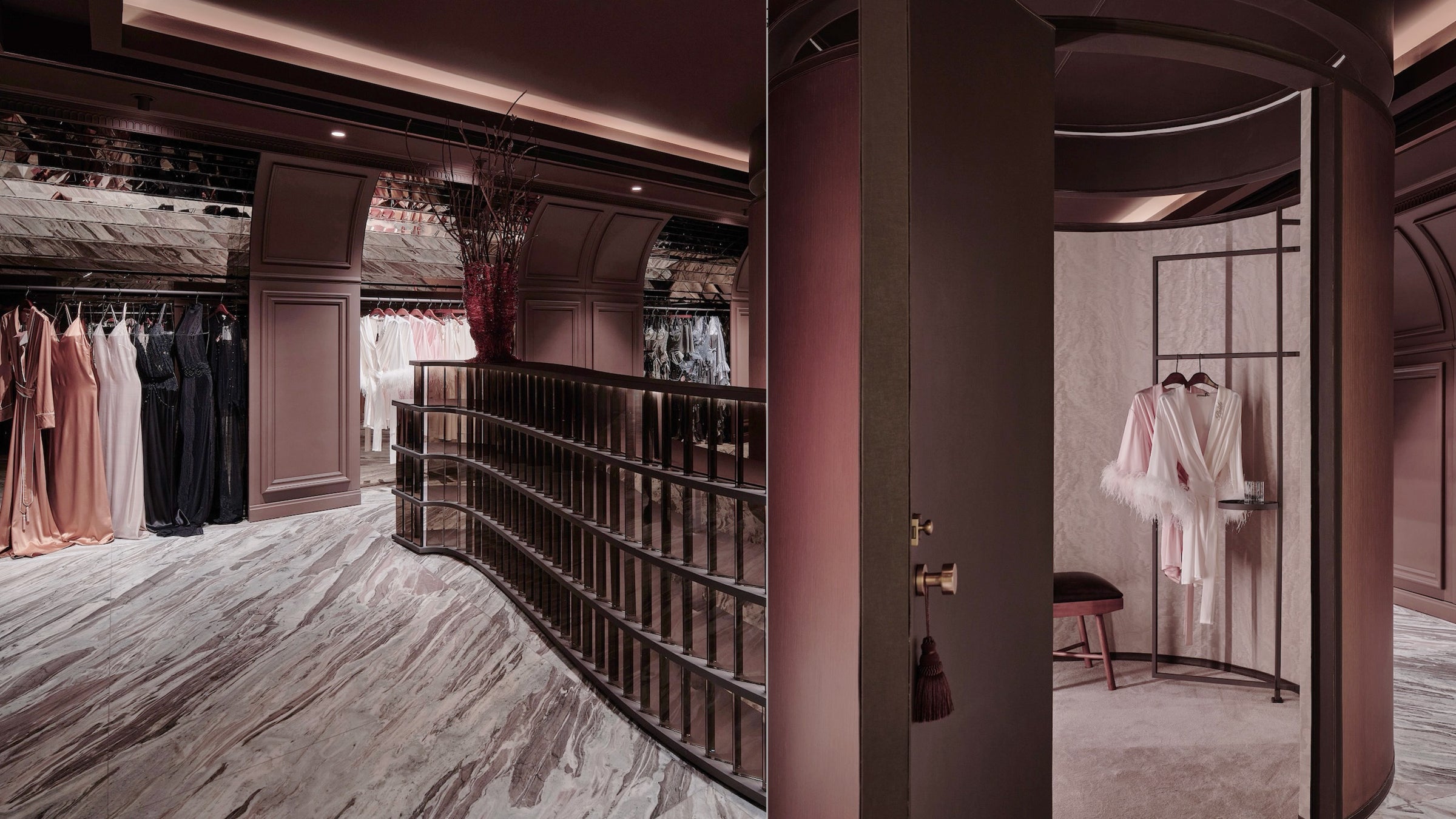 Luxury clothing store interior with dresses on racks and a marble floor.